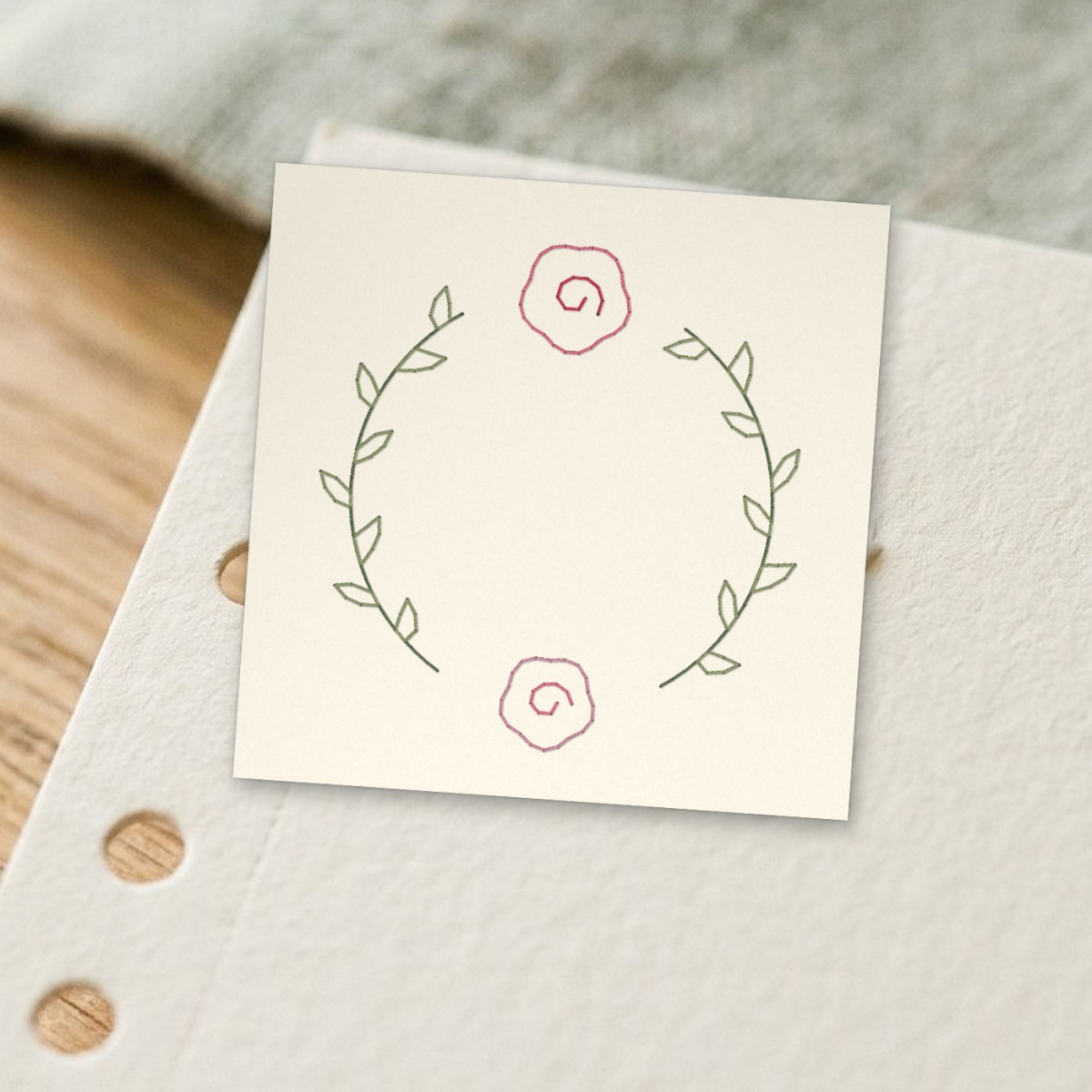 Open rose wreath stitched on paper